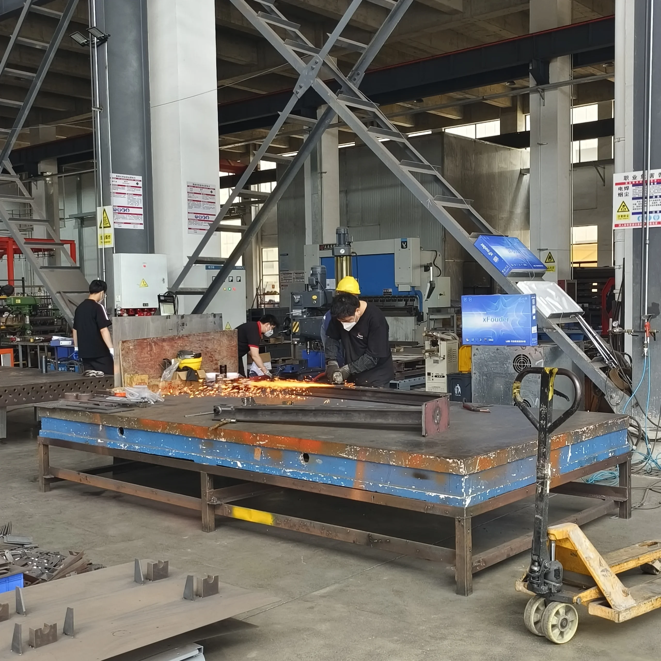 MIG welding technician assembling scissor lift chassis